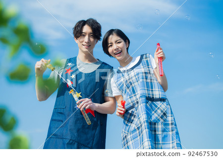 Nursery teacher men and women soap bubbles 92467530