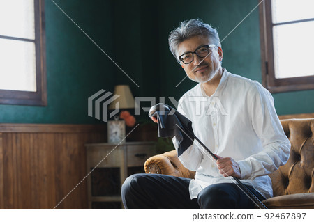 Gray-haired man polishing a golf club 92467897