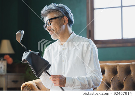 擦亮高爾夫球桿的灰髮男子 92467914
