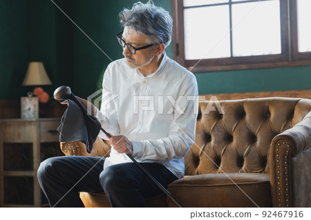 擦亮高爾夫球桿的灰髮男子 92467916