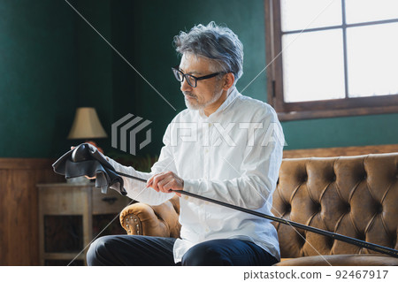 擦亮高爾夫球桿的灰髮男子 92467917