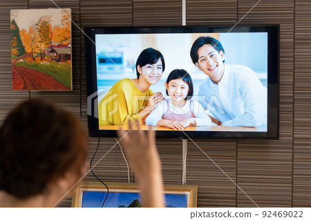 Senior woman talking to family on online TV Senior woman talking to family on online TV 92469022