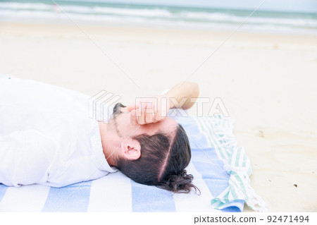 Men lying on the beach, heat stroke, sleeping Men lying on the beach, heat stroke, sleeping 92471494