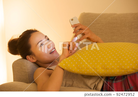 Female lying on the couch 92472952