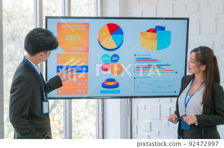 Two Young Thai Business people is presenting financial data on the Visual screen board in business meeting. Two Young Thai Business people is presenting financial data on the Visual screen board in business meeting. 92472997