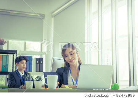 Asian. Female Operator is answering the phone for customer service sale and business consultant in a support office. Asian. Female Operator is answering the phone for customer service sale and business consultant in a support office. 92472999