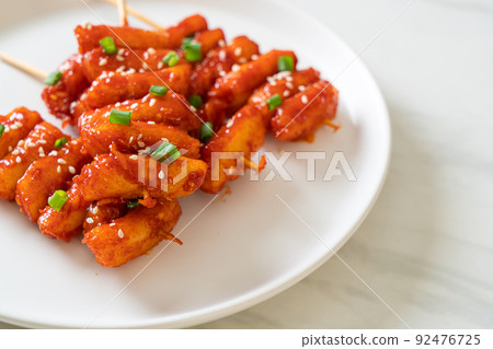deep fried Korean rice cake (Tteokbokki) skewered with spicy sauce deep fried Korean rice cake (Tteokbokki) skewered with spicy sauce 92476725