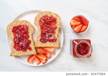 whole wheat bread with strawberry jam and fresh strawberry 92477864