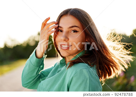Close up portrait of a young smiling brunette woman 92478788