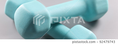 Blue two kilogram dumbbells on gray background 92479743