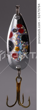 Triple metal spinner with fishing hooks on gray background Triple metal spinner with fishing hooks on gray background 92479764