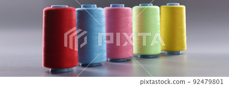 Fabric threads of different colors on gray background 92479801