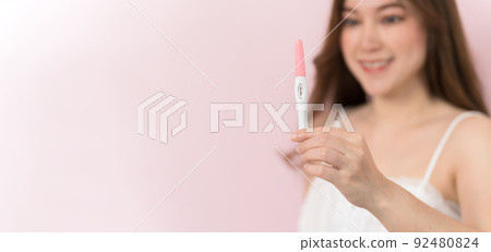 happy pregnant woman holding and showing positive pregnancy test happy pregnant woman holding and showing positive pregnancy test 92480824