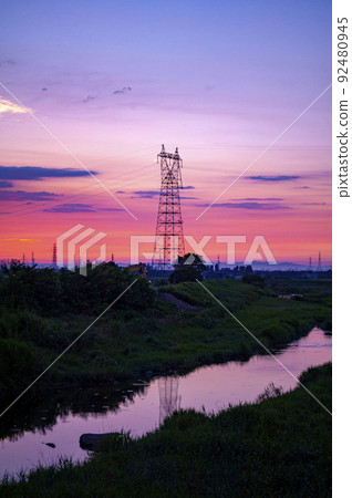 一座鋼塔倒映在一條被日落漸變色的河流中 92480945