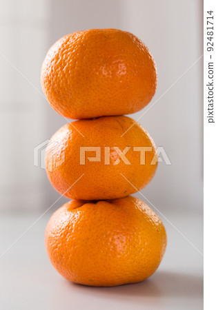 tower of three mandarines on white background 92481714