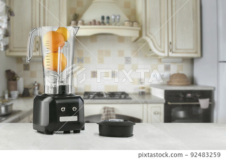 Blender and orange on wooden table in kitchen 92483259