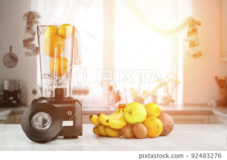 Blender, fruits and kitchen space. Sun flare 92483276