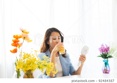 一個用電風扇尋求涼爽的女人 92484387