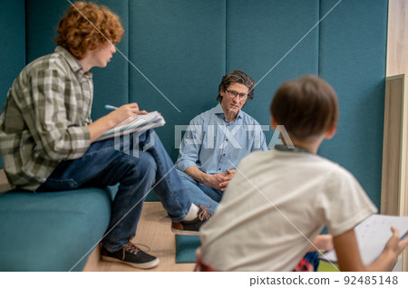 A teacher and his students discussing details of the project A teacher and his students discussing details of the project 92485148