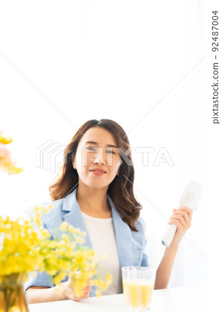 一個用電風扇尋求涼爽的女人 92487004