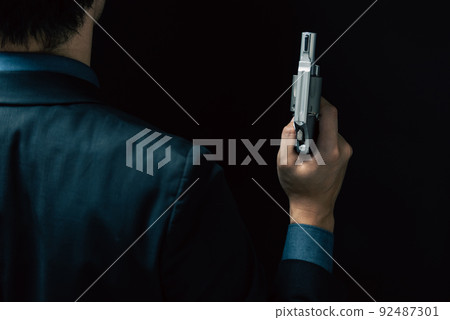 一個穿著西裝拿著手槍的人 92487301