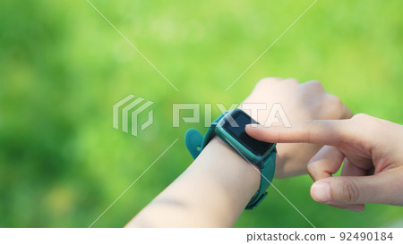 A woman using a smartwatch outdoors 92490184