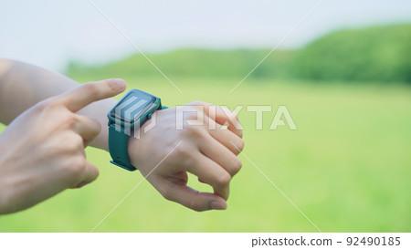 A woman using a smartwatch outdoors A woman using a smartwatch outdoors 92490185