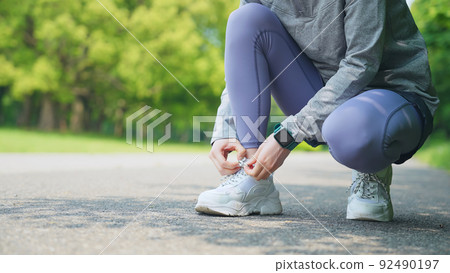 婦女在訓練前系鞋帶鍛煉慢跑 92490197