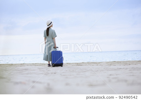 日本女人帶著手提箱站在海灘上 日本女人帶著手提箱站在海灘上 92490542