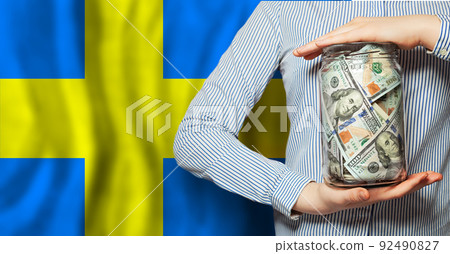 Hands holds US dollars money on Swedish flag background. Currency exchange, Hands holds US dollars money on Swedish flag background. Currency exchange, 92490827