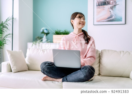 A young woman operating a laptop A young woman operating a laptop 92491383