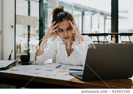 Tired mixed-race business woman with headache at office, feeling sick at work. Tired mixed-race business woman with headache at office, feeling sick at work. 92491500
