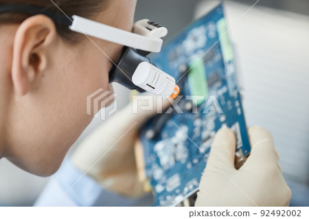 Female Engineer Working with Tech Parts Closeup Female Engineer Working with Tech Parts Closeup 92492002