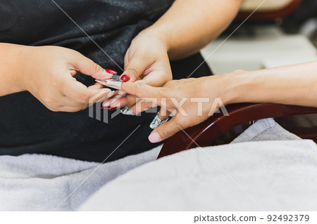 Woman getting a manicure in beauty spa salon. Woman getting a manicure in beauty spa salon. 92492379