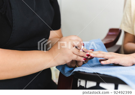 Female get professional manicure in beauty shop. Female get professional manicure in beauty shop. 92492399