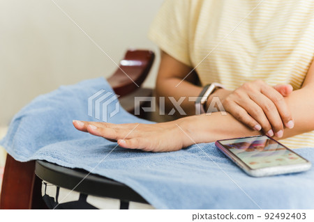 Woman finger with beautiful nails on blue towel in hand spa. Woman finger with beautiful nails on blue towel in hand spa. 92492403