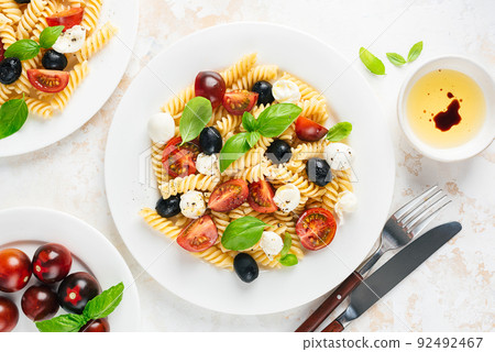 Cold pasta salad with fussili, cherry tomatoes, mozzarella cheese and olives 92492467