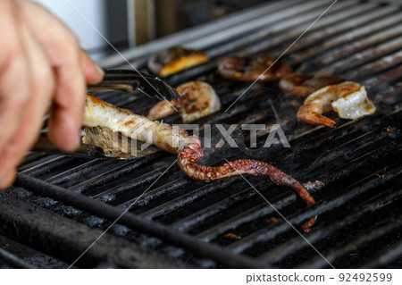 Process of grilling seafood on a barbecue grill over hot coal. Seafood recipes 92492599