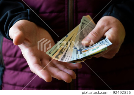 White male shows dollar bills in his hand closeup front view White male shows dollar bills in his hand closeup front view 92492836