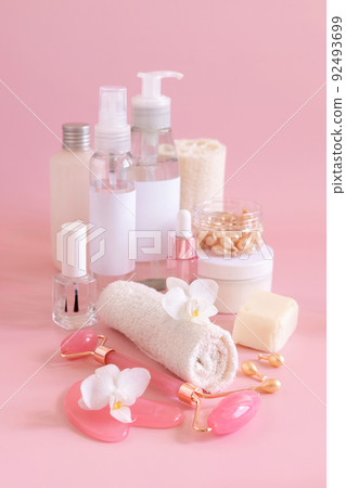 Natural cosmetic jars and skin care accesories with white orchid flower on pink close up, copy space Natural cosmetic jars and skin care accesories with white orchid flower on pink close up, copy space 92493699