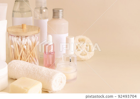 Natural cosmetic jarsand bottles and skin care accesories on light yellow close up 92493704