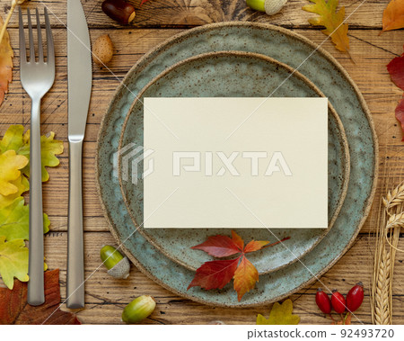 Autumn rustic table setting with blank card between leaves and berries top view, mockup 92493720