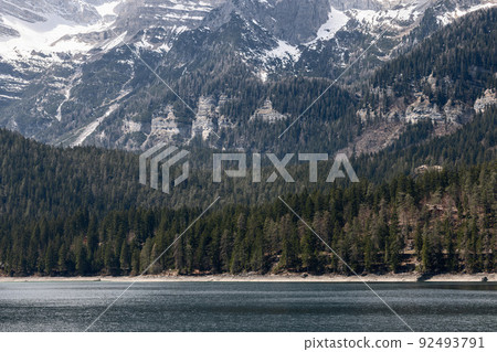 Tiny Alpine Tovel lake surrounded by age-old fir trees and rocks covered with eternal snow 92493791