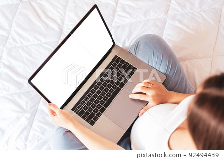 Pregnancy mockup digital laptop. Pregnant woman holding blank laptop screen. Mobile pregnancy online maternity application mock up. Concept maternity, pregnancy, childbirth. 92494439