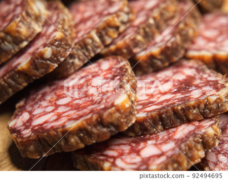 Delicious meat appetizer. Chunks of dried sausage taken in macro. Delicious meat appetizer. Chunks of dried sausage taken in macro. 92494695