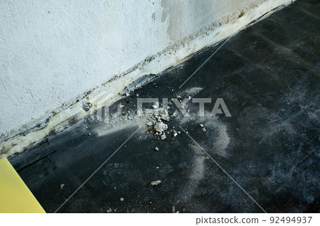 Worker sweeps construction debris with a broom. 92494937