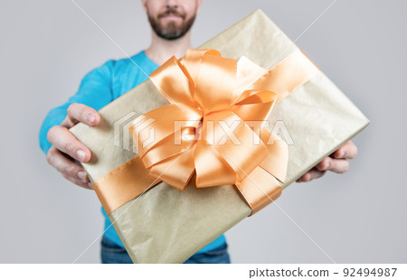present or gift box closeup in hands ofcropped man, selective focus, congratulations present or gift box closeup in hands ofcropped man, selective focus, congratulations 92494987