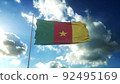 Flag of Cameroon waving at wind against beautiful blue sky. 3d illustration 92495169