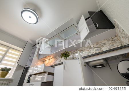 Renovated Interior for modern trendy white kitchen with doors open 92495255