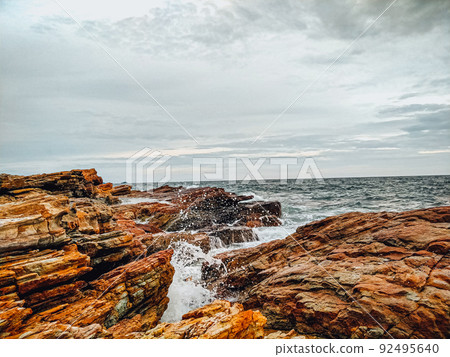 rocky coastline with ocean waves splashing on shore nature landscape background. 92495640